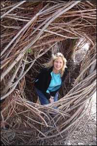 Woman looking through thatch house window