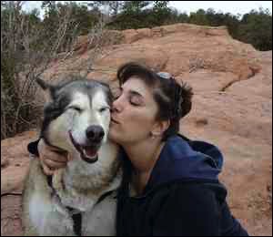 Woman kissing husky dog